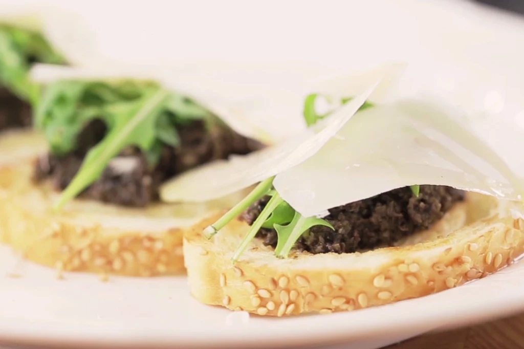  Bruschetta z tapenadą z czarnych oliwek i parmezanem Bruschetta z tapenadą z czarnych oliwek i parmezanem