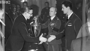 Pilot szybowcowy Tadeusz Góra otrzymuje nagrodę za najdłuższy przelot. Nagrodę wręcza wiceminister komunikacji Aleksander Bobkowski.