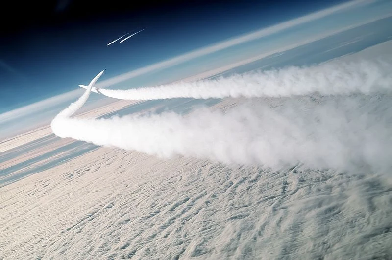 Smugi kondensacyjne pozostawione przez amerykańskie myśliwce F-15. W tle widoczne rosyjskie MiGi-29