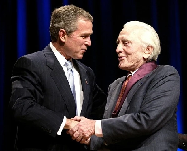 Kirk Douglas przyjmuje gratulacje od prezydenta George'a W.Busha po odebraniu państwowego odznaczenia za wybitne zasługi artystyczne.