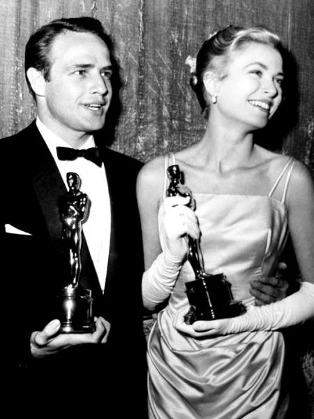 Mimo że rok później otrzymała Oscara za "Dziewczynę z prowincji" (na zdjęciu - z Marlonem Brando), w pamięci wielu kinomanów zapisała się jako dystyngowana, pewna siebie i fascynująca mężczyzn kobieta z filmów Hitchcocka.