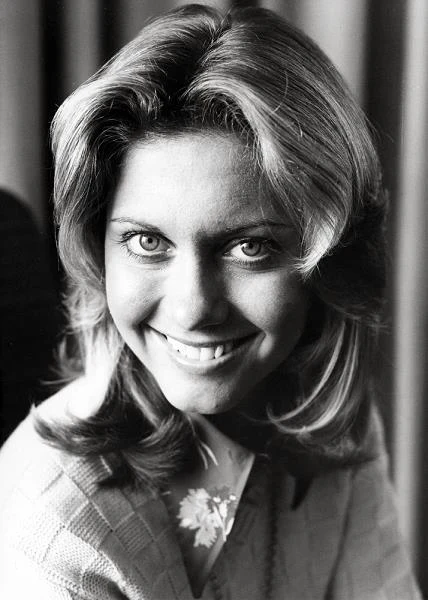 Olivia Newton-John to aktorka, piosenkarka i tancerka. Wydała ponad 30 albumów i czterokrotnie uhonorowano ją nagrodą Grammy. Zagrała w kilkunastu filmach telewizyjnych i kinowych, ale to rola Sandy Olsen w musicalu "Grease" z 1978 roku sprawiła, że została gwiazdą światowego kina. 26 września 2013 roku aktorka obchodzi 65. urodziny.