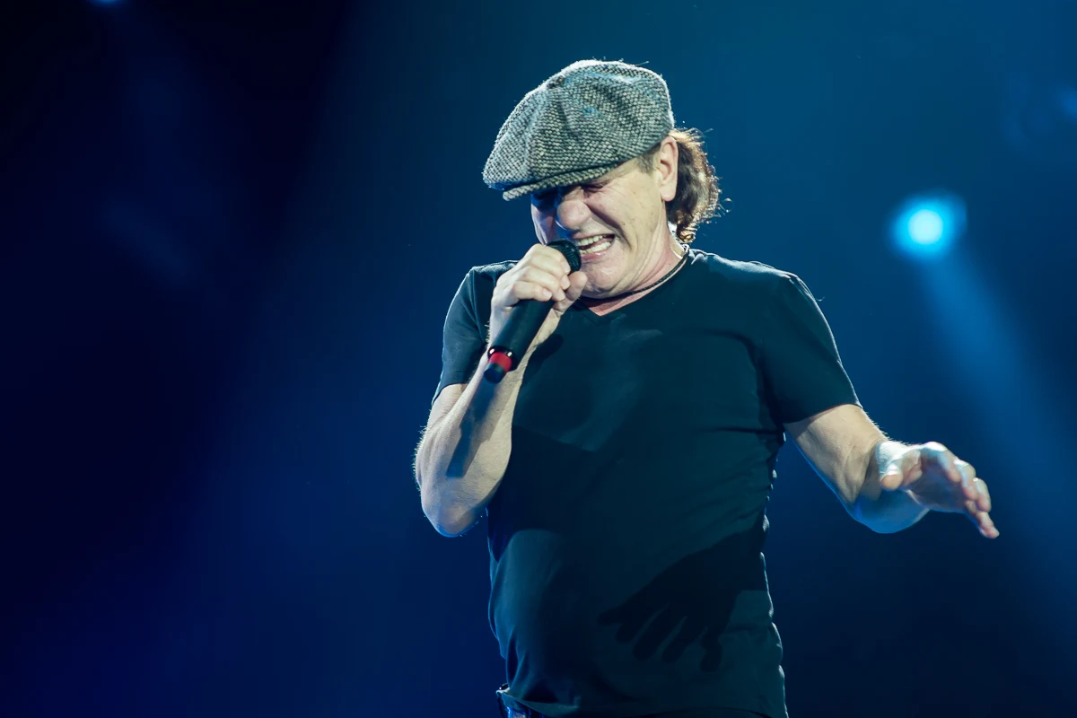 Brian Johnson występuje na scenie w charakterystycznym kaszkiecie