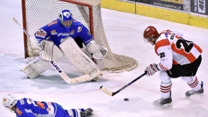 Hokeista Comarch Cracovii Maciej Kruczek (P) w ataku na bramkę Michala Fikrta (C) z Unii Oświęcim 