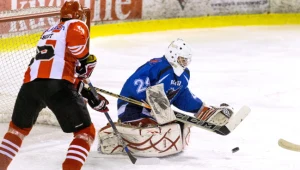 Hokeista Comarch Cracovii Grzegorz Pasiut (L) w ataku na bramkę Michała Czernika (P) z SMS U20 Sosnowiec