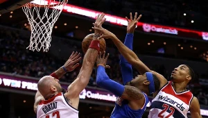 Marcin Gortat (z lewej) próbuje zablokować Carmelo Anthony'ego