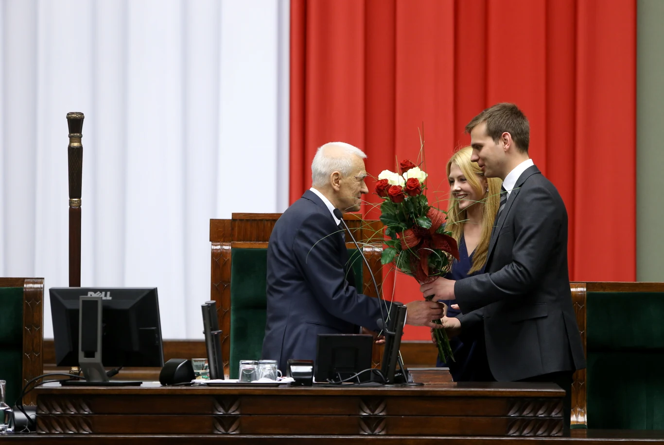 Marszałek-senior Kornel Morawiecki (C) odbiera kwiaty podczas pierwszego posiedzenia Sejmu VIII kadencji