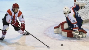  Kacper Guzik (L) z Comarch Cracovii atakuje bramkarza Ciarko PBS Bank STS Sanok Mateusza Skrablaka (P)podczas meczu hokejowej Ekstraklasy w Krakowie