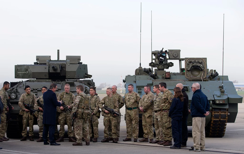 Premier David Cameron i brytyjscy żołnierze przy sprzęcie bojowym