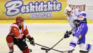 Hokeista Unii Oświęcim Kamil Paszek (L) walczy o krążek z Patrykiem Noworytą (L) z Comarch Cracovii 