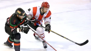 Hokeista Comarch Cracovii Krystian Dziubiński (P) walczy o krążek z Michałem Kolarzem (L) z GKS Tychy 