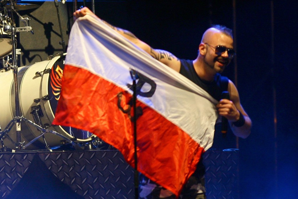 Joakim Broden (Sabaton) z symbolem Polski Walczącej na biało-czerwonej fladze