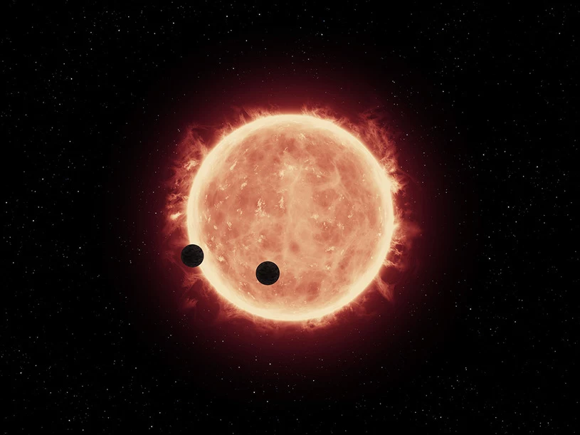 Rysunek pokazujący planety TRAPPIST-1b i TRAPPIST-1c, przechodzące przed tarczą swej gwiazdy