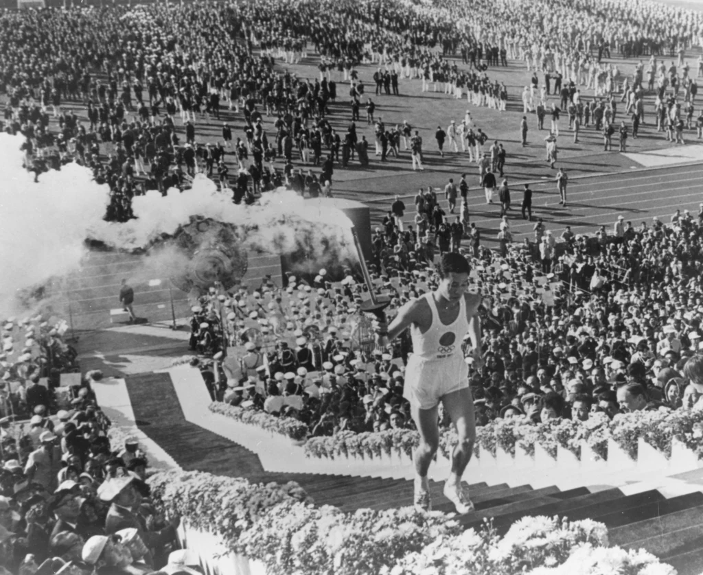 Jednym z najważniejszych wydarzeń igrzysk olimpijskich jest moment zapalenia znicza. Często tej chwili nadaje się symboliczne znaczenie. Nie inaczej było podczas igrzysk w Tokio w 1964, kiedy to znicz zapalił Yoshinori Sakai, urodzony w dniu zrzucenia bomby atomowej na Hiroszimę. Jednym z najważniejszych wydarzeń igrzysk olimpijskich jest moment zapalenia znicza. Często tej chwili nadaje się symboliczne znaczenie. Nie inaczej było podczas igrzysk w Tokio w 1964, kiedy to znicz zapalił Yoshinori Sakai, urodzony w dniu zrzucenia bomby atomowej na Hiroszimę.