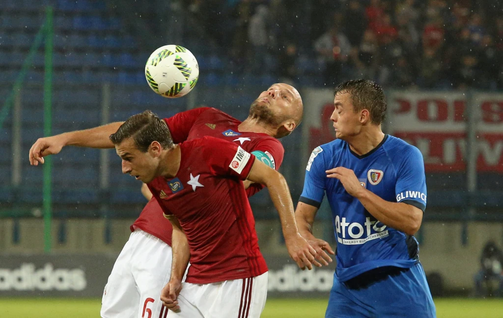 Arkadiusz Głowacki i Boban Jović walczą o piłkę z Michałem Masłowskim Arkadiusz Głowacki i Boban Jović walczą o piłkę z Michałem Masłowskim