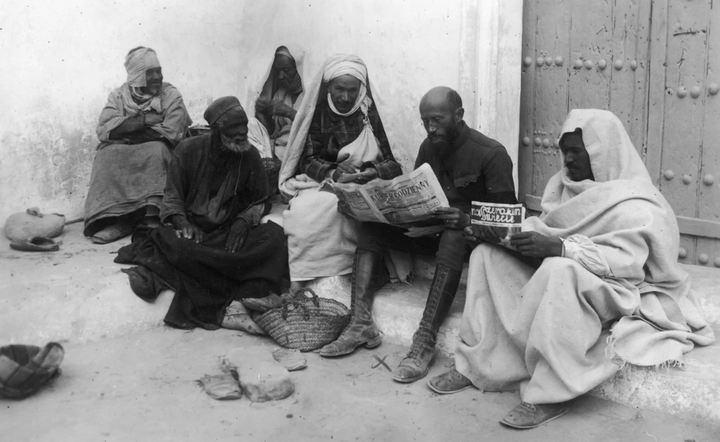 Kazimierz Nowak z mieszkańcami oazy Gadames przegląda gazety, grudzień 1931 rok. Fot. NAC