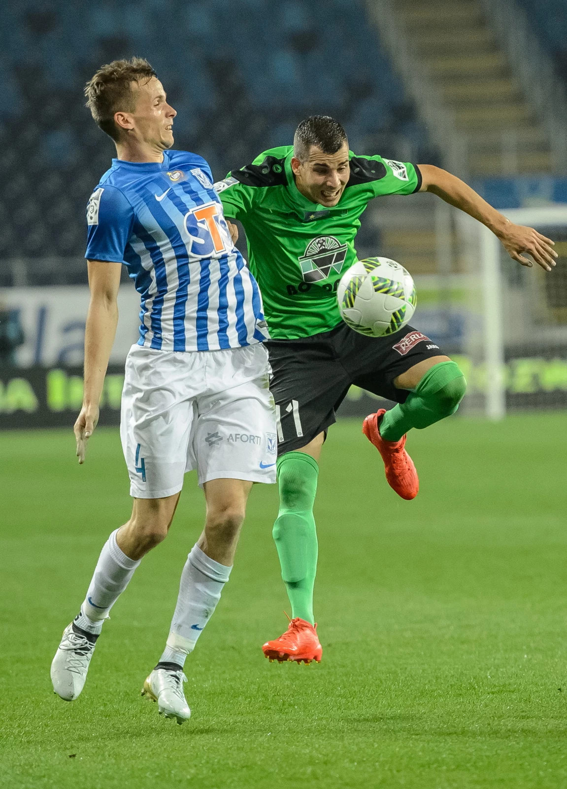 Piłkarz Górnika Łęczna Jurisa Slaven (P) i Tomasz Kędziora (L) z Lecha Poznań