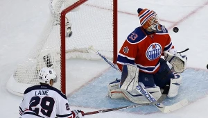 Cam Talbot z Edmonton Oliers broni strzał Patrika Laine'a z Winnipeg Jets