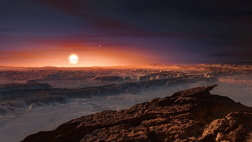 Wizja artystyczna powierzchni planety Proxima b, orbitującej wokół czerwonego karła Proxima Centauri. W tle widoczne pozostałe dwie gwiazdy tego układu wielokrotnego Alfa Centauri AB