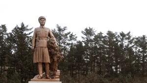 Kin Dzonh Il (w środku) przed posągiem swojej matki, Kim Dzong Suk /zdj. z 2009 roku