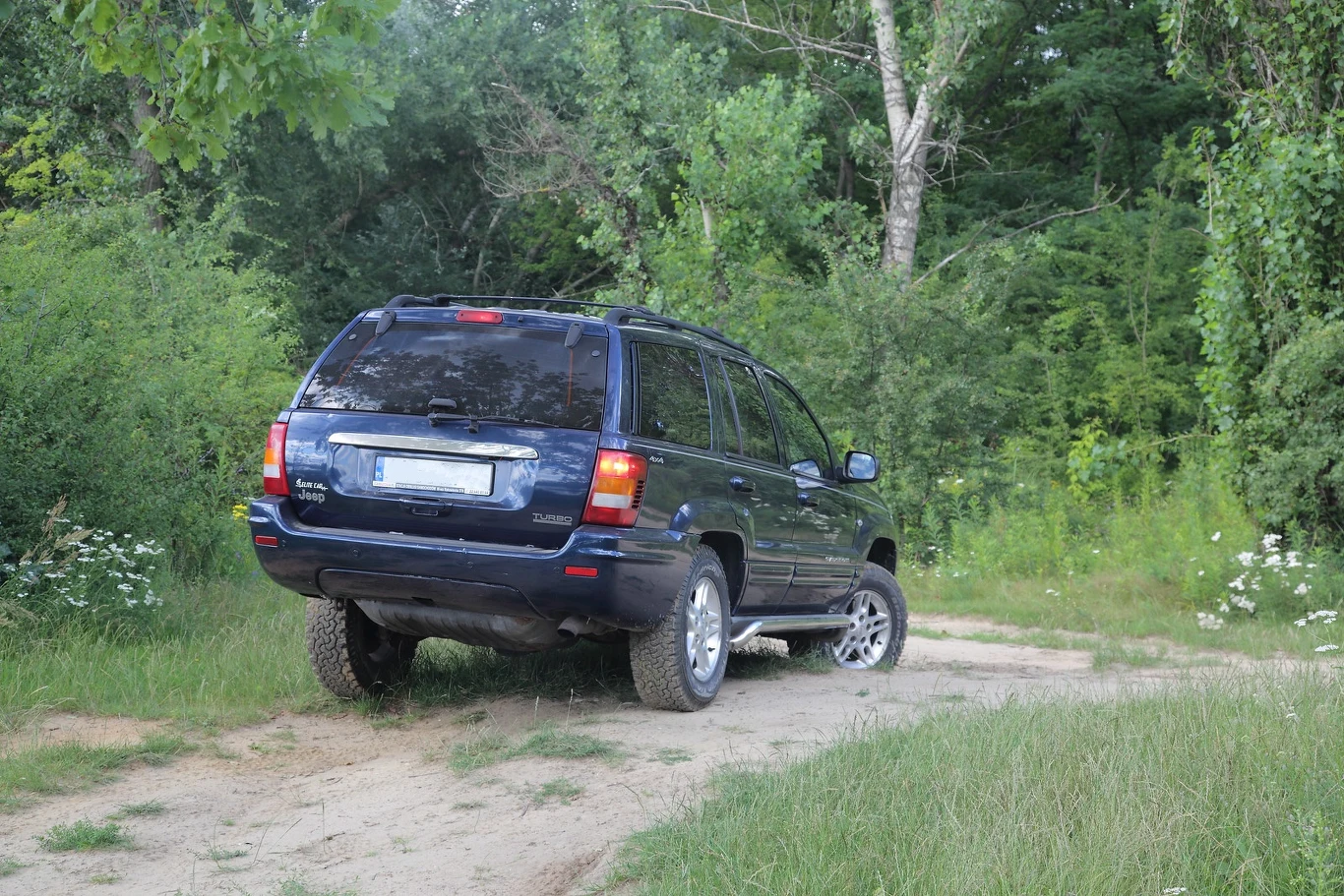 W terenie Jeep radzi sobie znakomicie. Duży prześwit, względnie mały zwis przedni, wielkie koła z terenowymi oponami i stały napęd 4x4: mimo braku ramy „Grand” to bardzo twardy zawodnik.