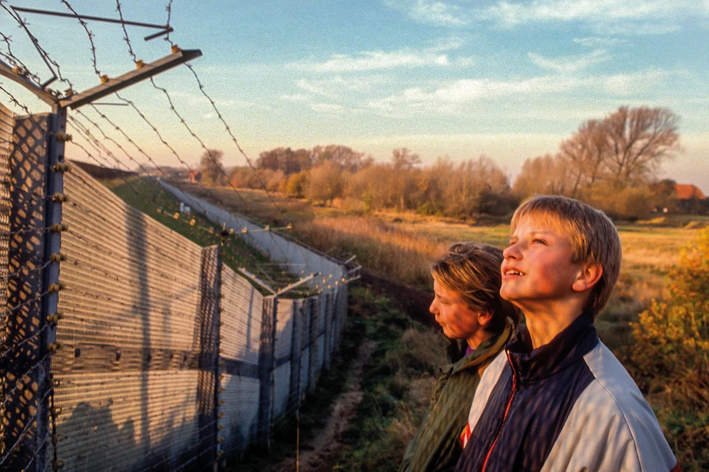 Niemiecka Republika Demokratyczna. Młodzi Niemcy z pobliskiej wsi przy płocie granicznym , za który wolno im wejść po raz pierwszy w życiu./Fotografia pochodzi z albumu "1989. Rok nadziei"