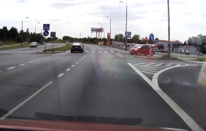 Czerwony samochód wjeżdża na skrzyżowanie