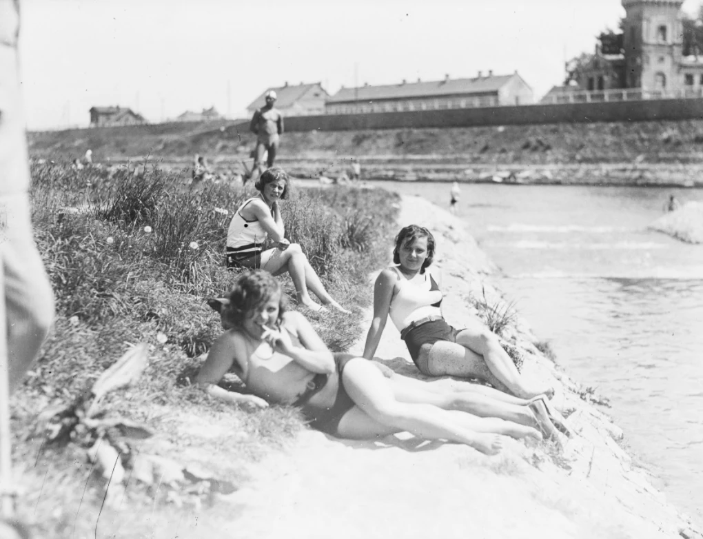 Plażowiczki podczas wypoczynku. W tle widoczny fragment pałacu Lasockich. Plaża Towarzystwa Uniwersytetu Robotniczego w Krakowie (zdjęcie z 1931 roku)