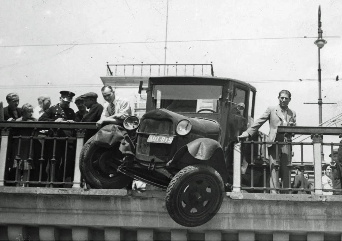1938 r. Samochód ciężarowy zawieszony na krawędzi wiaduktu Pancera po uderzeniu w barierkę na Nowym Zjeździe. Widoczni gapie oraz policjant spisujący zeznania świadków.
