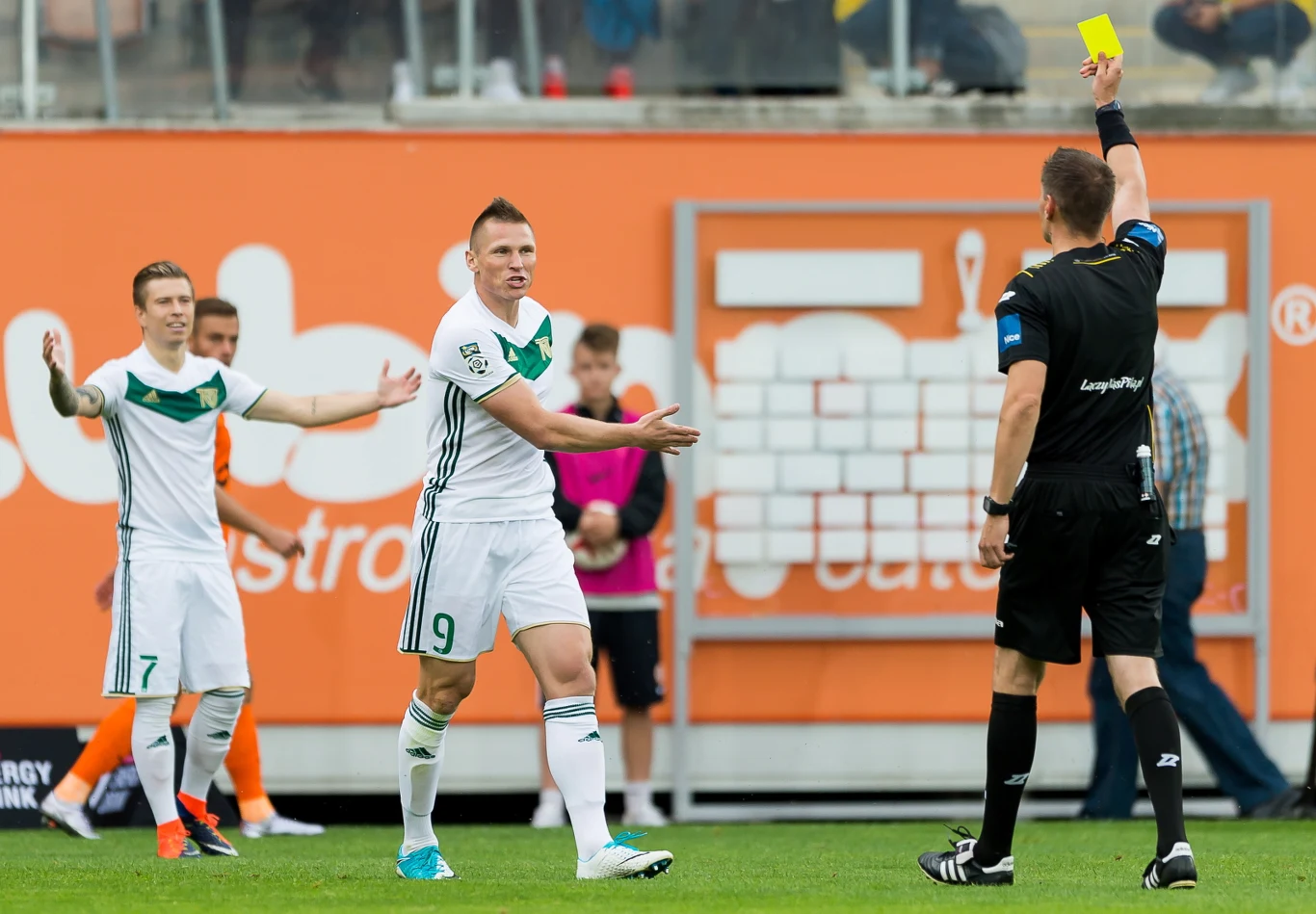 Sędzia Tomasz Kwiatkowski (P) pokazuje żółtą kartkę Marcinowi Robakowi (C) ze Śląska Wrocław