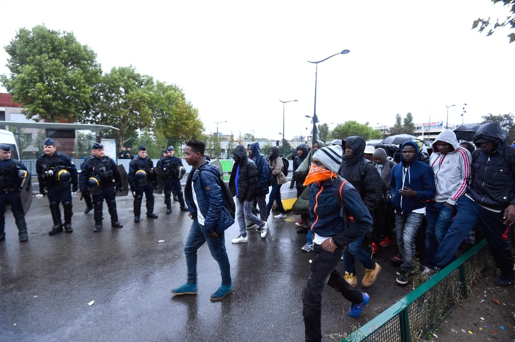 Francuska policja wyprowadza imigrantów z prowizorycznego obozu Francuska policja wyprowadza imigrantów z prowizorycznego obozu