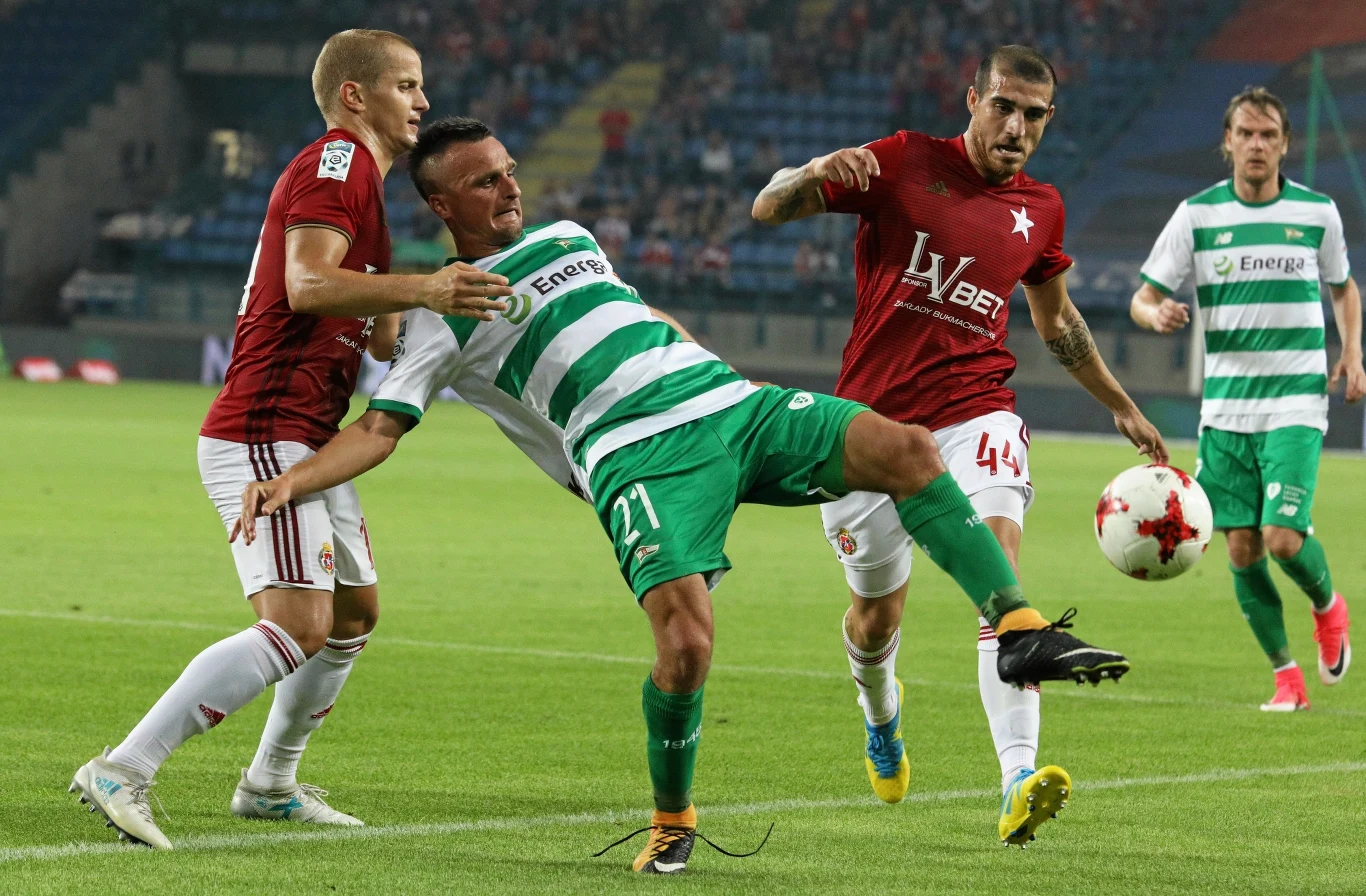 Tomasz Cywka (z lewej) i Fran Velez (z prawej) walczą o piłkę ze Sławomirem Peszką