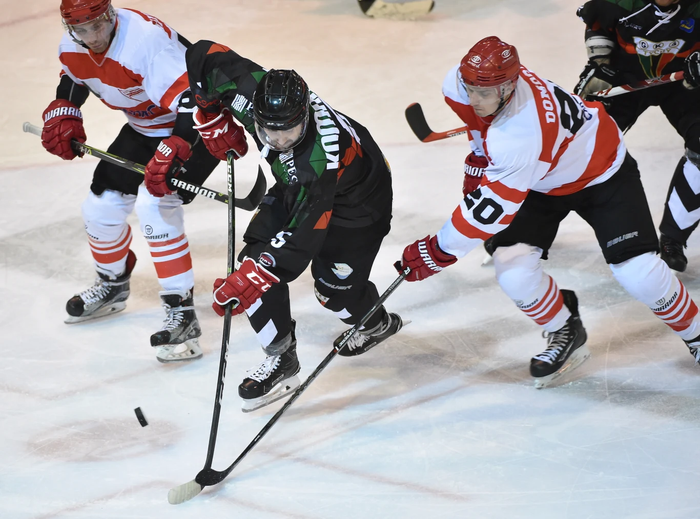 Hokeiści Comarch Cracovii Krystian Dziubiński (L) i Adam Domogała (P) oraz Filip Komorski (C) z GKS Tychy