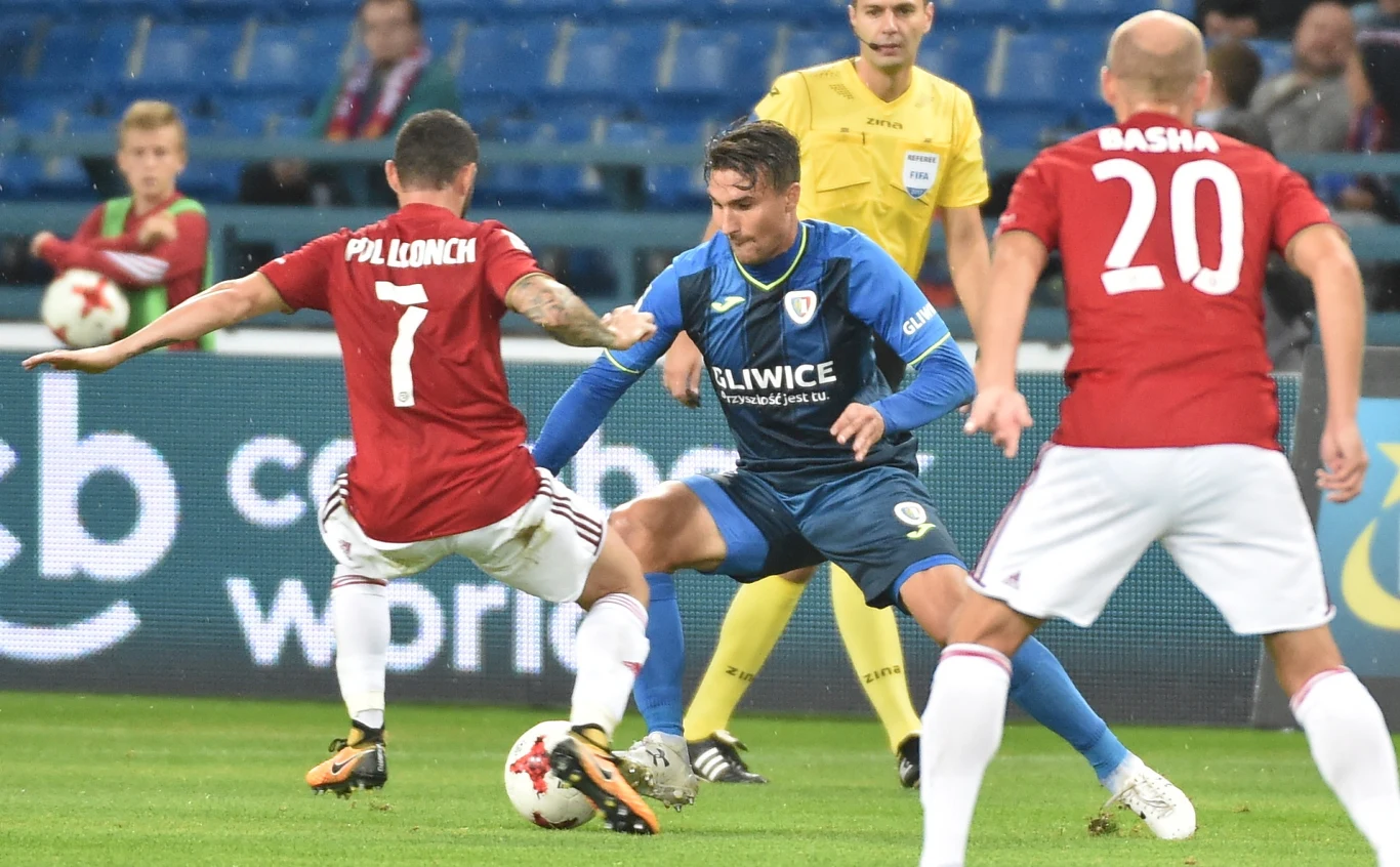 Piłkarze Wisły Kraków Pol Lionch (L) i Vullnet Basha (P) oraz Michal Papadopulos (C) z Piasta Gliwice