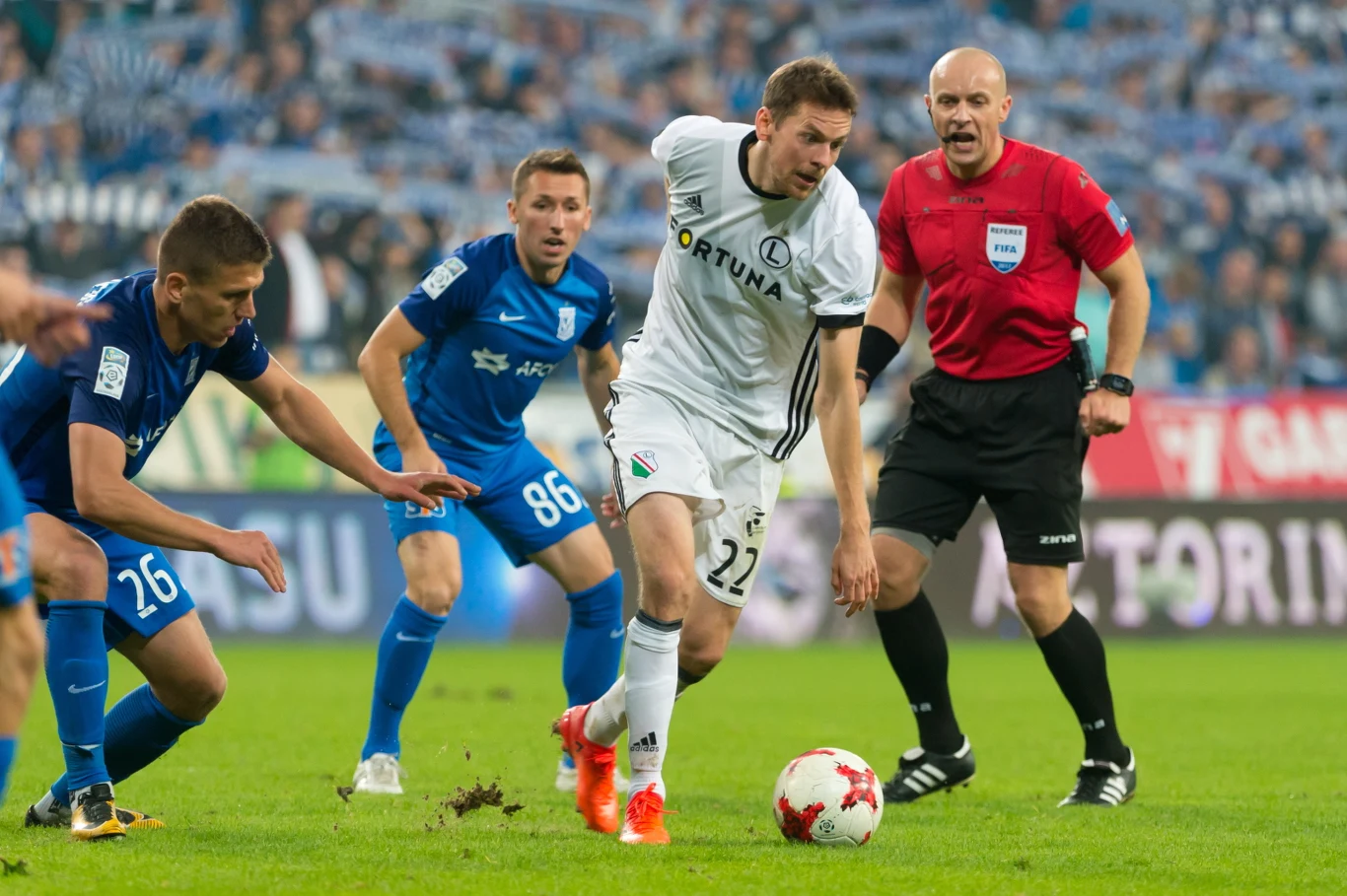 Zawodnicy Lecha Poznań Rafał Janicki (L) i Radosław Majewski (2L) oraz Kasper Hamalainen (2P) z Legii Warszawa i sędzia główny Szymon Marciniak