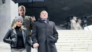 Paweł Gajewski trzyma parasol nad Kurskim i jego narzeczoną