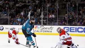 Bramkarz Cam Ward z Caroliny Hurricanes nie zdołał powstrzymać Brenta Burnsa #88 z San Jose Sharks.
