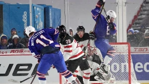 Casey Mittelstadt #11 z USA styrzela, a Adam Fox #8 skacze, by zasłonić widoczność bramkarzowi Carterowi Hartowi #31 z Kanady.