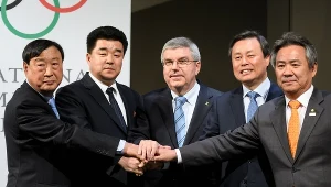 Thomas Bach (w środku) z przedstawicielami Korei Północnej i Południowej