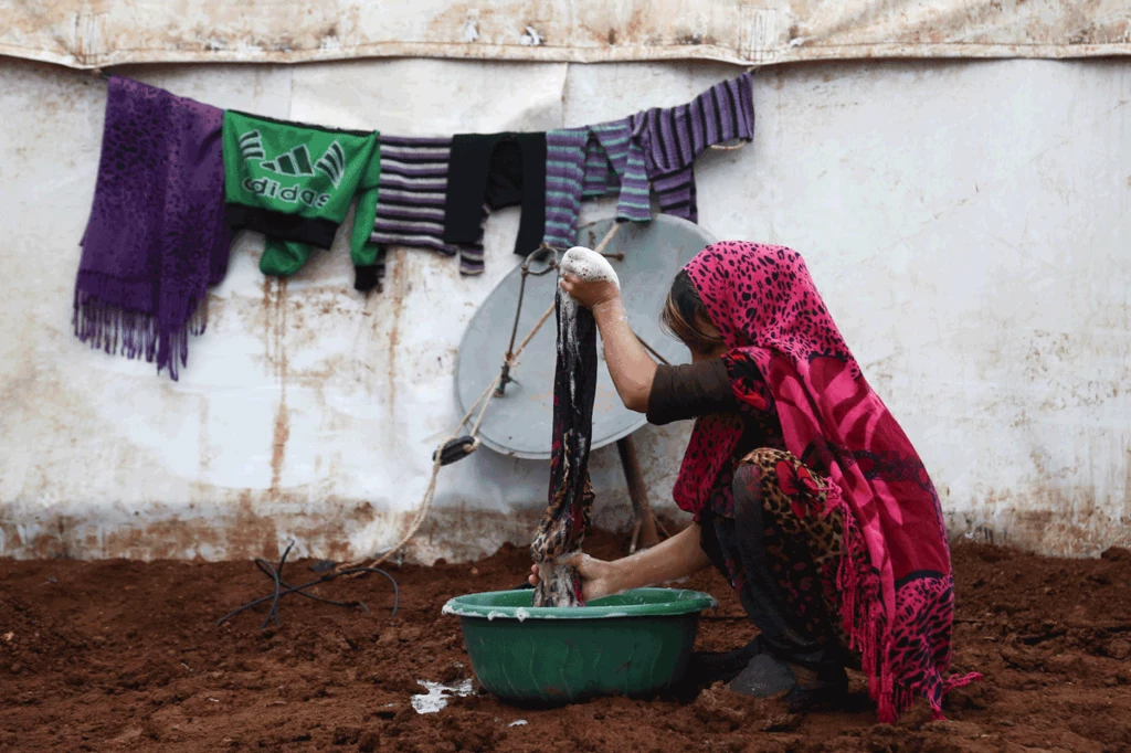 Przesiedlona syryjska kobieta z prowincji Idlib robi pranie w prowizorycznym obozie w pobliżu miasta Azaz w północnej Syrii