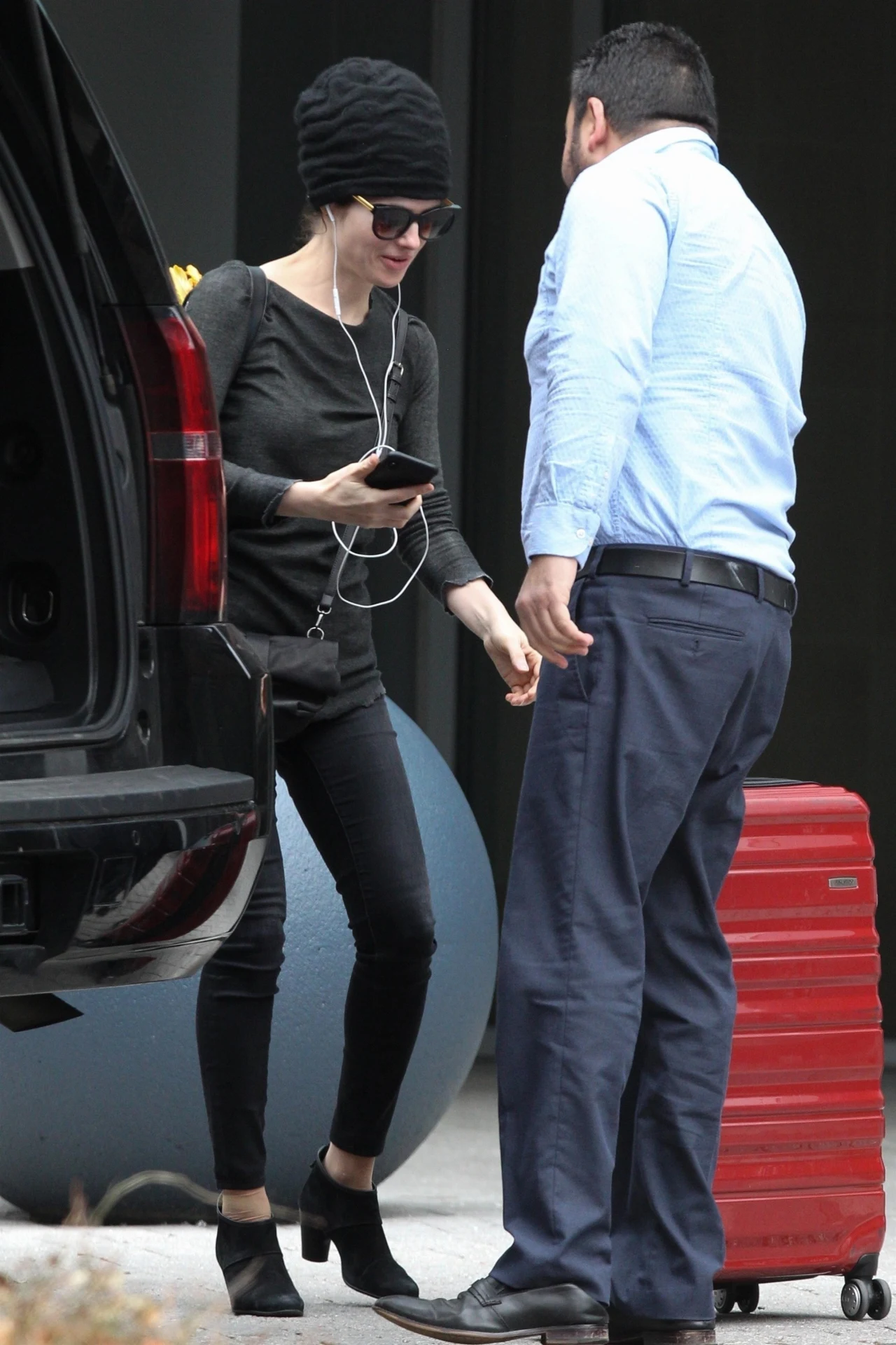 Kobieta próbuje ukryć się pod czapką i ciemnymi okularami Kobieta próbuje ukryć się pod czapką i ciemnymi okularami