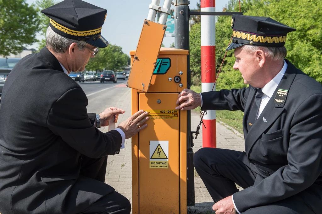 Zastępca dyrektora zakładu linii kolejowych w Lublinie Lech Olszewski (L) i dyrektor zakładu linii kolejowych w Lublinie Andrzej Matysiewicz (P) oznaczają przejazd nową naklejką