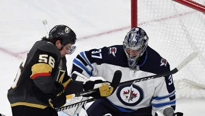 Connor Hellebuyck #37 ze Winnipeg Jets broni strzał Erika Hauli #56 