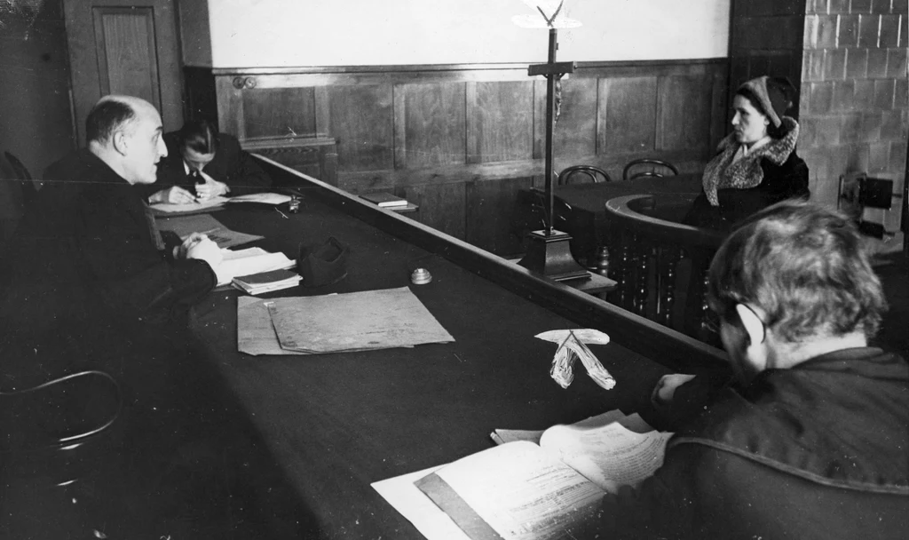 Sędzia przesłuchujący kobietę w sądzie grodzkim w Krakowie (domena publiczna)