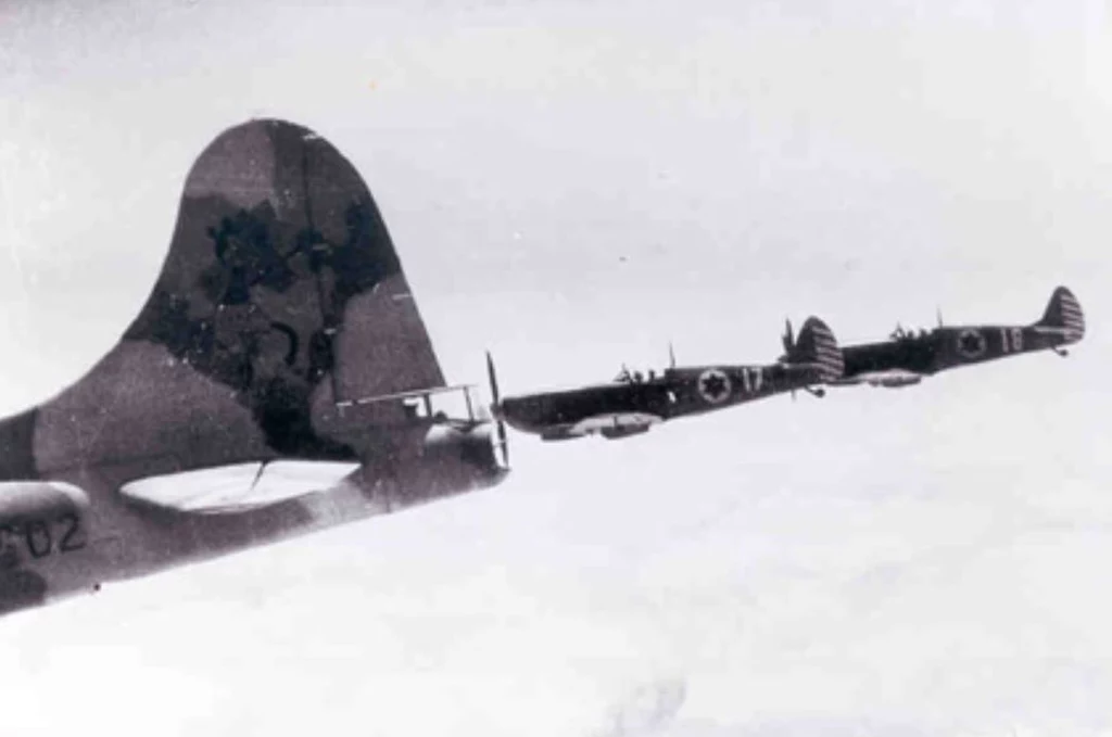 B-17 z namalowaną na stateczniku Myszką Miki, w eskorcie Spitfire Mk.IX podczas lotu bojowego nad Egiptem. Styczeń 1949 roku