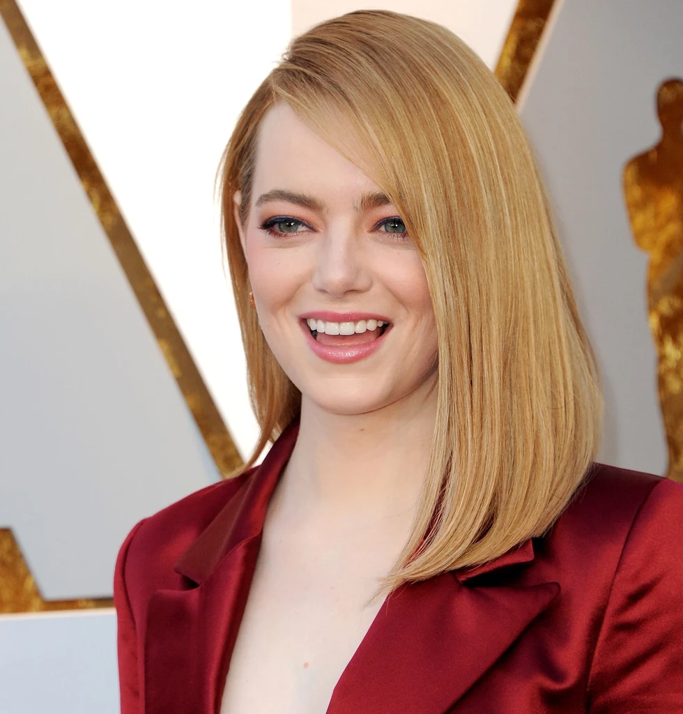 Włosy do ramion i przedziałek po boku - Emma Stone w idealnej fryzurze dla pań o pełnej buzi