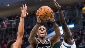 DeMar DeRozan z San Antonio między Malcolmem Brogdone i  Thonem Makerem z Milwaukee Bucks.