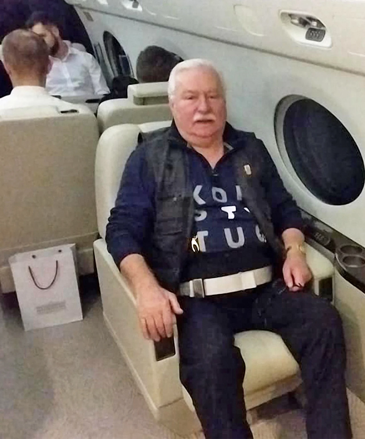 Były prezydent Lech Wałęsa w koszulce z napisem "Konstytucja" na pokładzie prezydenckiego samolotu w drodze na pogrzeb George'a W.H. Busha Były prezydent Lech Wałęsa w koszulce z napisem "Konstytucja" na pokładzie prezydenckiego samolotu w drodze na pogrzeb George'a W.H. Busha