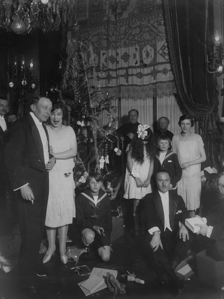 Uczestnicy Wigilii w Ambasadzie RP w Paryżu zgromadzeni przy choince w 1926 roku. Na kolację wigilijną raczej nie podano wówczas karpia na dziesięć sposobów (domena publiczna)