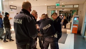 Podejrzany o atak mężczyzna wyprowadzany przez policjantów. 